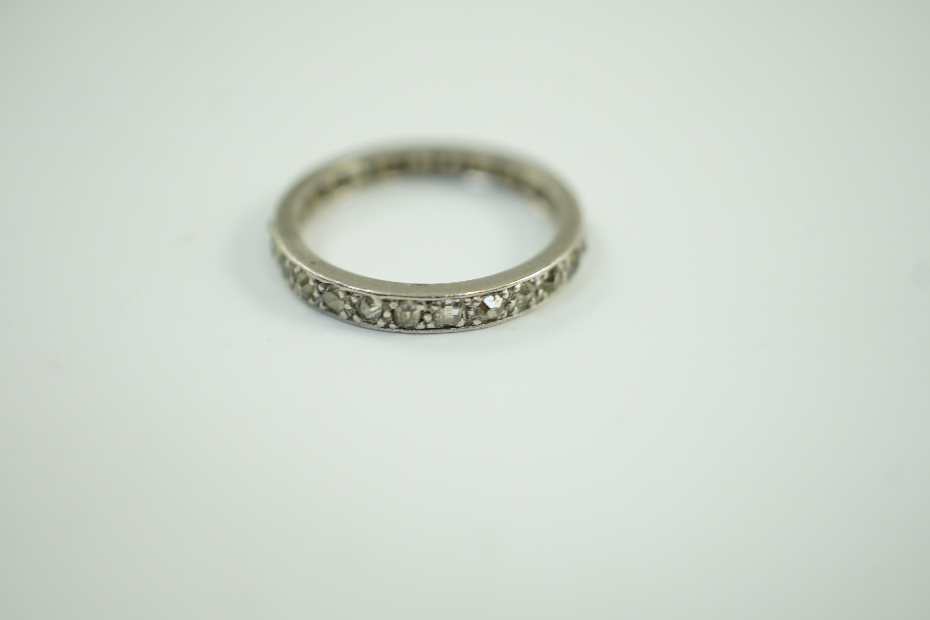 A white metal and diamond chip set full eternity ring, size L, gross weight 2.7 grams.